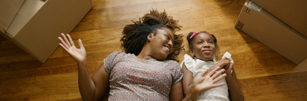 women with little girl on the floor happily surrounded by boxes