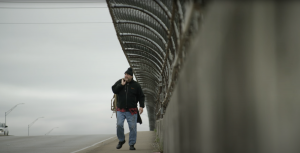 person experiencing homelessness walking along bridge