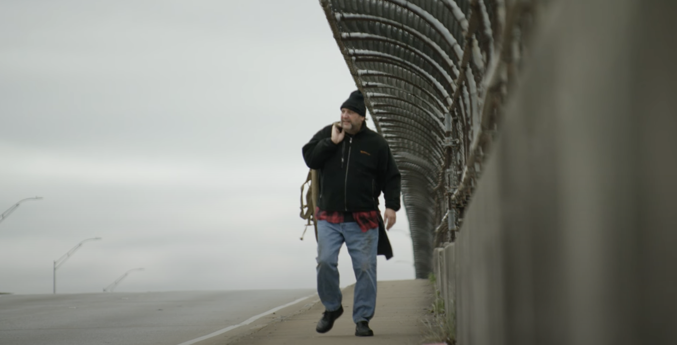 person experiencing homelessness walking along bridge