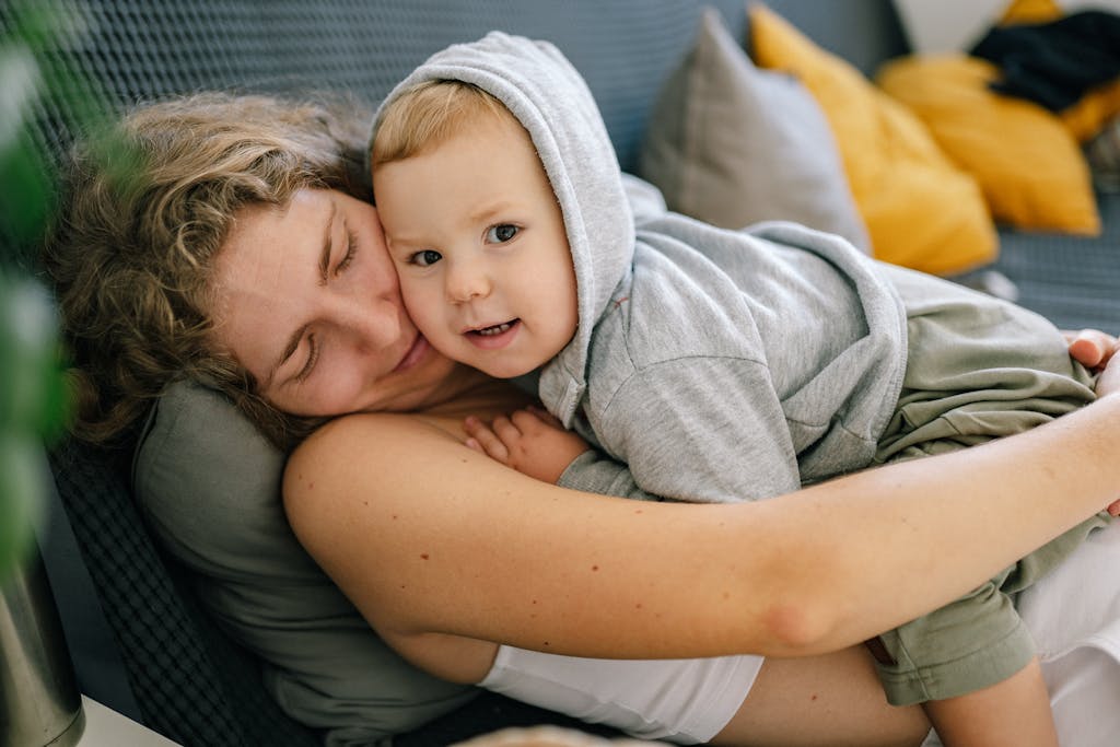 Mother and son cuddling on a sofa, creating a warm and loving family moment.