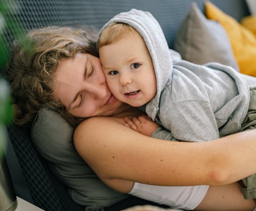 Mother and son cuddling on a sofa, creating a warm and loving family moment.